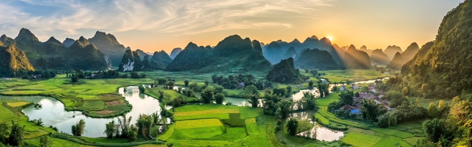 Vietnamese train traveling through lush green fields, an indirect route for Da Nang to Hoi An.